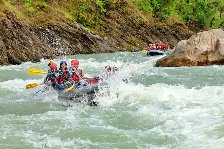 A raft crew paddling through white-water rapids