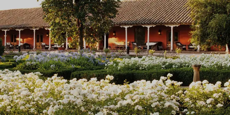 The Santa Rita colonial house behind a garden of white flowers